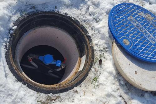 Odprt vodomerni jašek na snegu