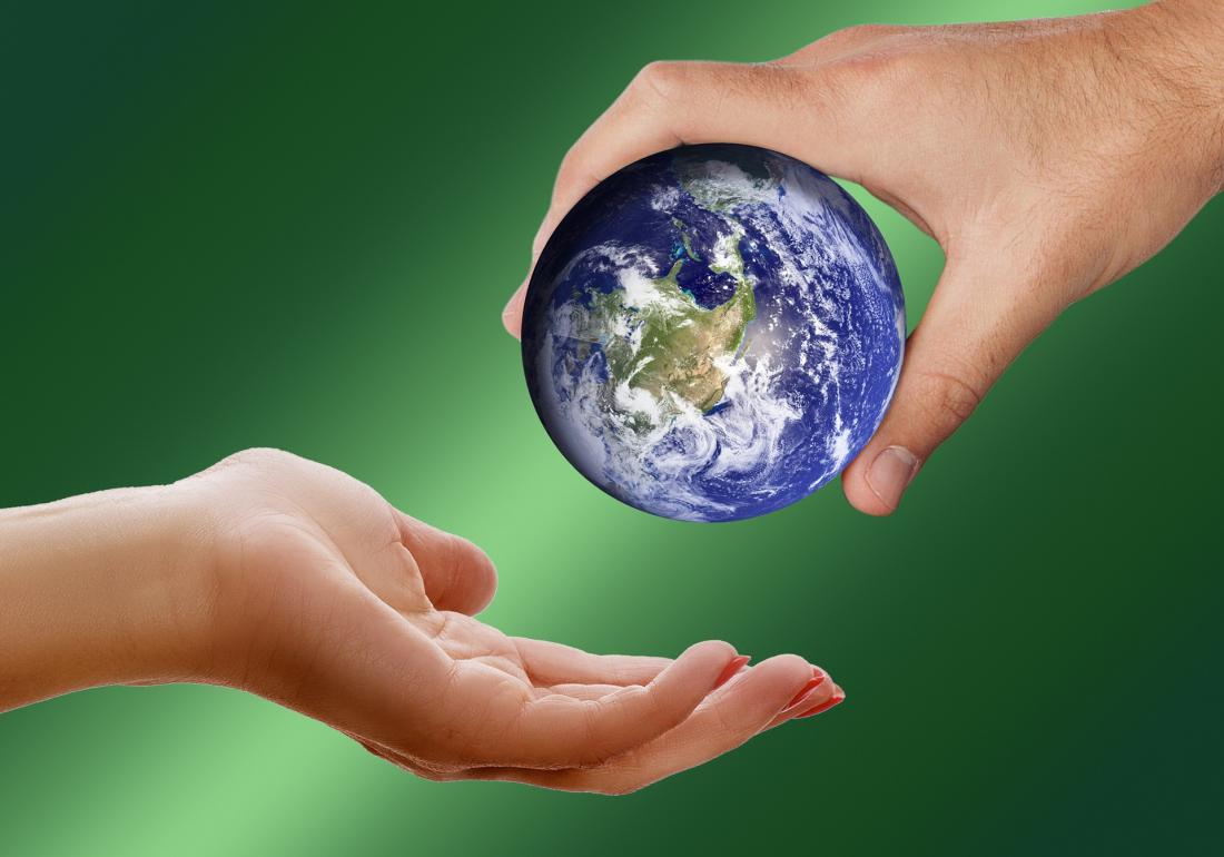 Slika prikazuje planet Zemljo v človeških rokah.